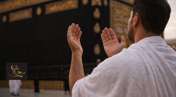 معتمر يرفع يديه بالدعاء أمام الكعبة